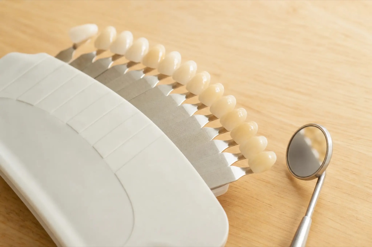 A tooth shade guide fan beside a dental mirror